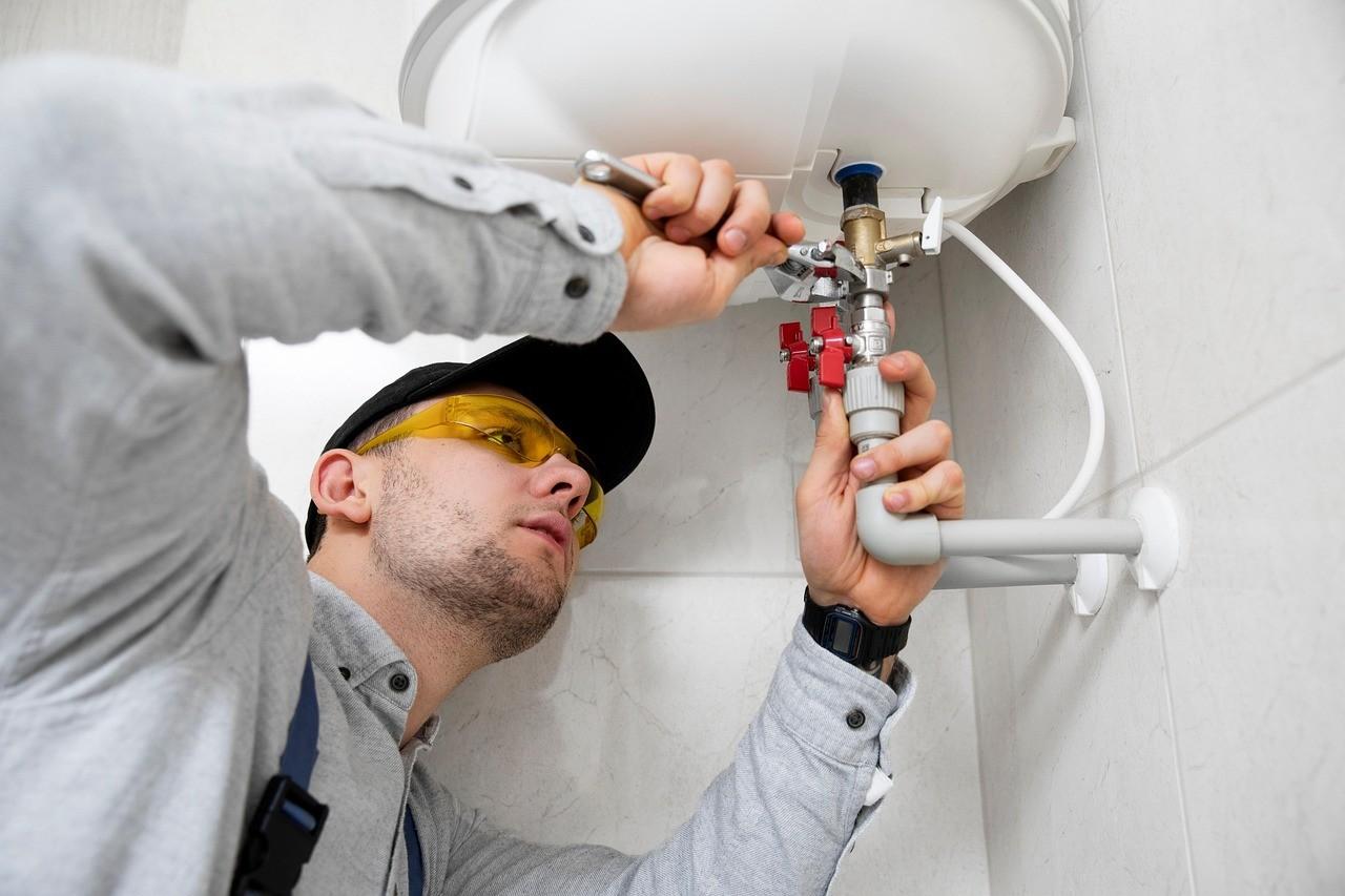 a plumber fixing a pipe with a wrench