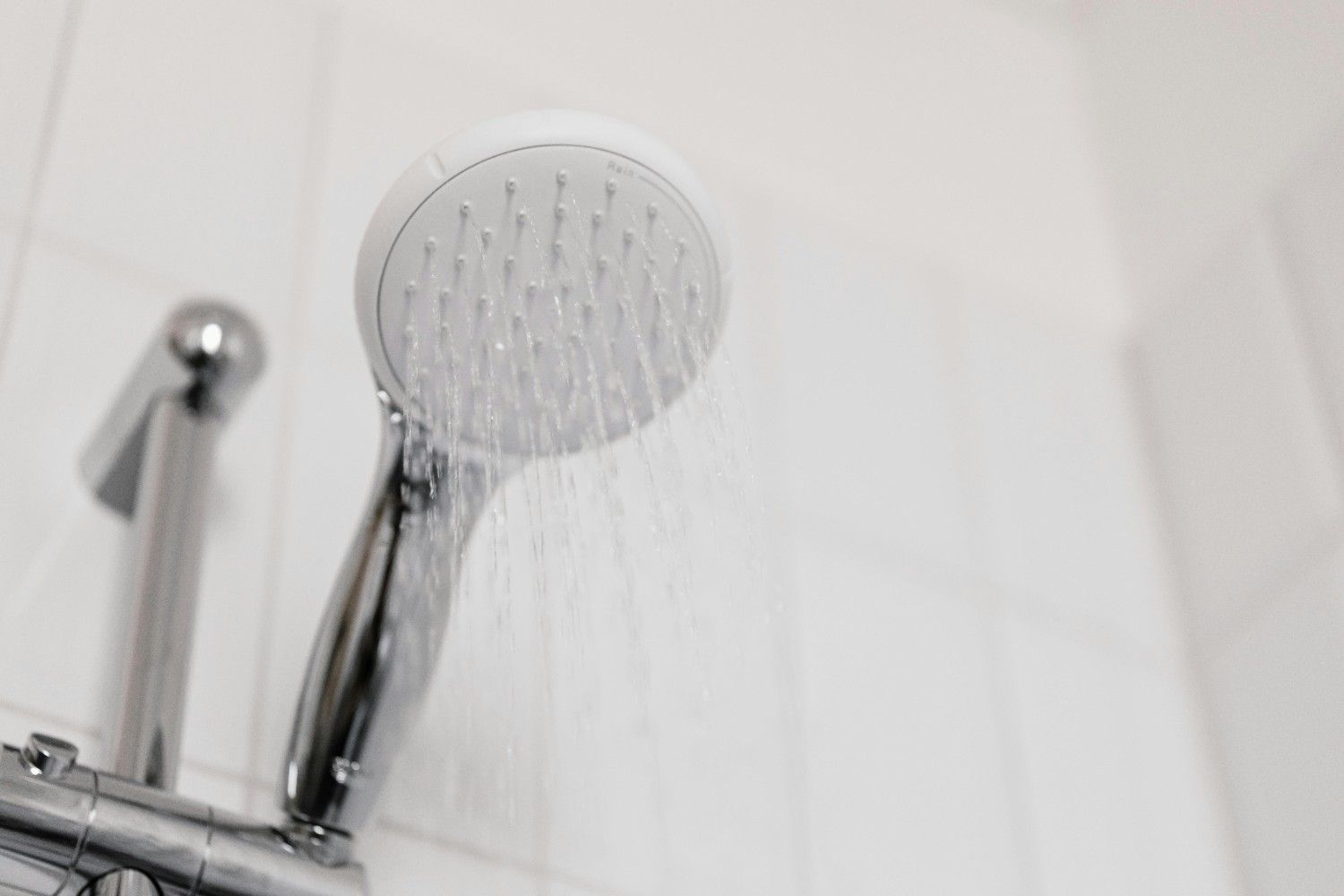 stainless shower head inside a white bathroom