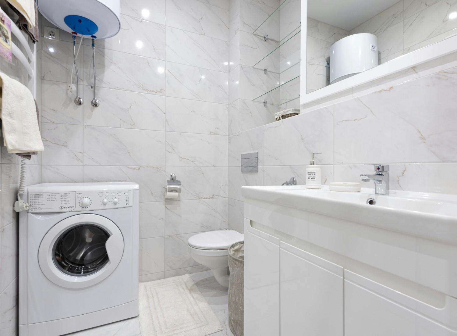 bathroom water heater Minimalist bathroom featuring a washing machine and modern fixtures